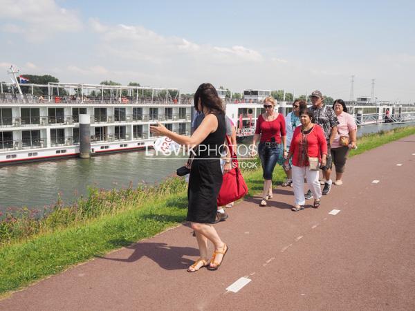 Gids begeleid passagiers cruiseschip naar de molens van de Kinderdijk [00976551]