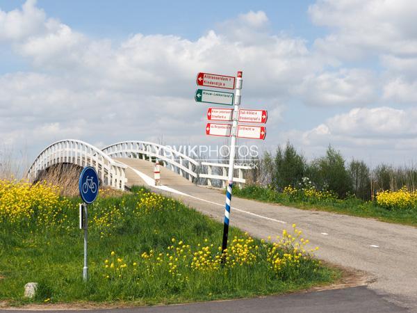 Fietsbrug met wegwijzer in polderlandschap [00993293]