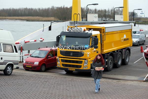 Vervoersmiddelen en personen gaan vanaf veerpont aan wal [782305]