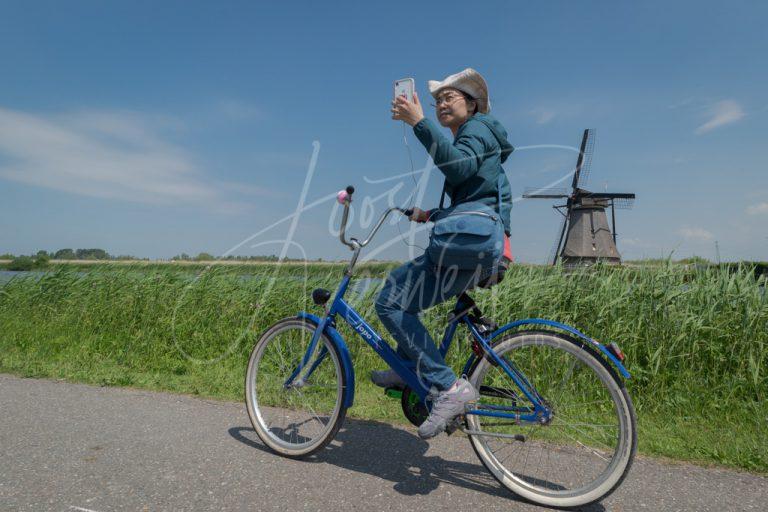 Vrouw maakt selfie op fiets bij Kinderdijk D810000506