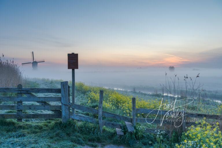 Mistig landschap bij zonsopkomst