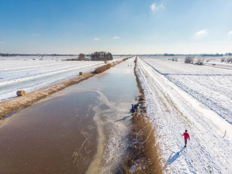 Luchtfoto van kluinen tijdens schaatstocht op natuurijs