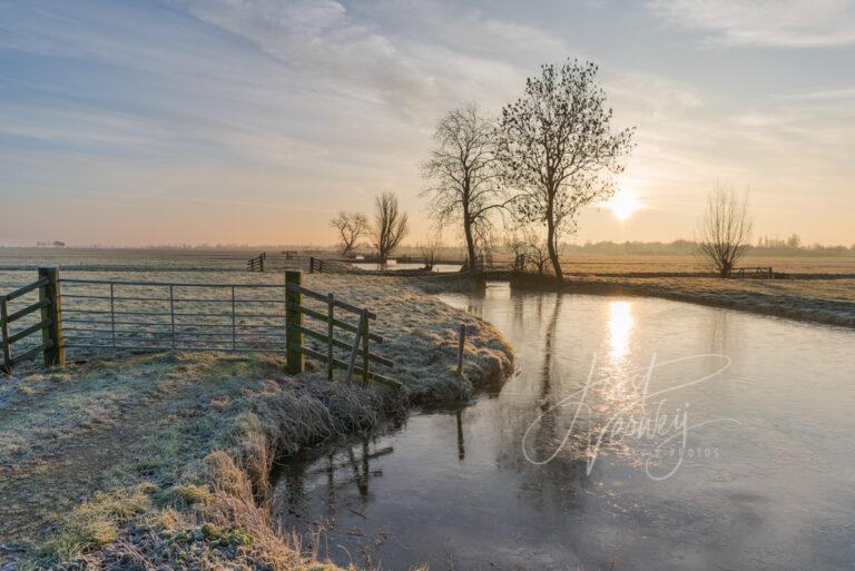 Zonsopkomst in winters polderlandschap